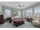 Spacious bedroom with a ceiling fan, light green walls, and natural light from multiple windows at 2595 Ross Rd, Snellville, GA 30039