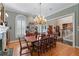 Elegant dining room features striped wallpaper, chandelier, and a wooden table with seating for ten at 2595 Ross Rd, Snellville, GA 30039