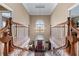 A grand foyer features a high ceiling, second-story window, chandelier, and dual staircases with wooden railings at 2595 Ross Rd, Snellville, GA 30039