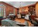 Elegant home office boasts wood paneling, built-in bookshelves, a fireplace, and ample seating for work or relaxation at 2595 Ross Rd, Snellville, GA 30039