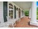 This home's brick-laid front porch is lined with white columns and rocking chairs, offering idyllic outdoor seating at 2595 Ross Rd, Snellville, GA 30039