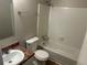 This bathroom features a tub and shower combination, single sink, toilet, mirror, and white tiling at 3951 Mcgill Dr, Decatur, GA 30034