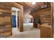 Spacious attic with wooden ceiling and walls and a bathroom with a blue shower curtain at 228 Indian Creek Rd, Locust Grove, GA 30248