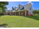 Charming home featuring a covered patio, lush green lawn, and inviting backyard space at 228 Indian Creek Rd, Locust Grove, GA 30248