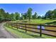 Scenic pond with wooden fence and green surroundings adding natural charm to the property at 228 Indian Creek Rd, Locust Grove, GA 30248