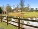 Scenic pond with a wooden fence, reflecting trees and sky, offering a tranquil and serene view at 228 Indian Creek Rd, Locust Grove, GA 30248