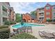 Community outdoor pool featuring lounge chairs, dining tables, landscaping, and brick buildings at 3063 Chastain Park Ne Ct, Atlanta, GA 30342