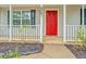 Charming red front door with black shutters and a well maintained front yard at 4547 Atha Cir, Loganville, GA 30052