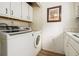 A functional laundry room equipped with a washing machine, dryer, cabinetry, and sink at 556 Country Greens Dr, Jonesboro, GA 30238