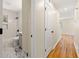 Hallway view of the bathroom with a white-tiled shower/tub, grey vanity, and marble flooring at 817 N Evelyn Nw, Atlanta, GA 30318
