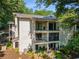 Three-story condo building featuring balconies with black metal railings and lush surrounding greenery at 1150 Collier Nw Rd # L14, Atlanta, GA 30318