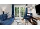 Bright living room with a comfortable blue sofa, armchair, and access to a private balcony at 1150 Collier Nw Rd # L14, Atlanta, GA 30318