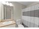 Bathroom vanity with a large mirror and a toilet with a striped shower curtain at 165 Heaton Place Trl, Covington, GA 30016