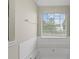 Bathtub and window provide natural light in this serene bathroom with neutral tile backsplash at 165 Heaton Place Trl, Covington, GA 30016