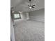 Open bedroom with plush carpeting, ceiling fan, and a large window, offering a cozy and inviting space at 165 Heaton Place Trl, Covington, GA 30016