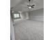 Open bedroom with plush carpeting, ceiling fan, and a large window, offering a cozy and inviting space at 165 Heaton Place Trl, Covington, GA 30016