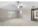 Neutral bedroom with a large window, plush carpeting, and ceiling fan with vaulted ceiling at 165 Heaton Place Trl, Covington, GA 30016