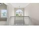 Bright hallway featuring a large arched window, decorative chandelier, and neutral paint at 165 Heaton Place Trl, Covington, GA 30016