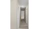 Hallway featuring neutral walls, carpet flooring, and white doors with passage to other rooms at 165 Heaton Place Trl, Covington, GA 30016