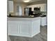 Kitchen featuring white cabinets, breakfast bar and stainless steel microwave at 165 Heaton Place Trl, Covington, GA 30016