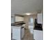 Kitchen featuring breakfast bar, stainless steel microwave, white cabinets, and tiled floors at 165 Heaton Place Trl, Covington, GA 30016