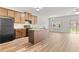 Open kitchen with wood cabinets, island, black appliances and adjacent dining area at 1931 Old Dogwood, Jonesboro, GA 30238