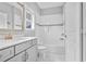 Bright bathroom featuring a bathtub, shower, gray vanity, gold faucet, and a large mirror at 2029 Havenhurst Way, Auburn, GA 30011