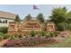 Landscaped entrance sign for Retreat at Ashbury Park with colorful flowers and an American flag at 2029 Havenhurst Way, Auburn, GA 30011