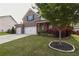 Beautifully landscaped front yard with mature trees, green grass, and a well-maintained lawn, complements the brick home at 2029 Havenhurst Way, Auburn, GA 30011