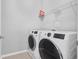 Modern laundry room featuring front-load washer and dryer set, shelving, and ample counter space at 2029 Havenhurst Way, Auburn, GA 30011