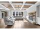 Bright living room boasts a coffered ceiling, stone fireplace, hardwood floors and large comfortable sectional sofa at 2029 Havenhurst Way, Auburn, GA 30011