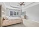 Bedroom with tray ceiling, fan, large windows, and a plush bed at 2029 Havenhurst Way, Auburn, GA 30011