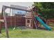Outdoor playground with a slide, swings, and climbing area in a grassy backyard for to enjoy at 2029 Havenhurst Way, Auburn, GA 30011