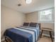 Comfortable bedroom with natural light from the window and a cozy blue and white striped bed at 205 Plantation Sw Rd, Smyrna, GA 30082