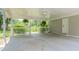 Spacious carport featuring concrete flooring, a white door, and hanging plants at 205 Plantation Sw Rd, Smyrna, GA 30082