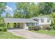 Charming split-level home featuring a manicured lawn, bright blue door, and covered carport, inviting you to call it home at 205 Plantation Sw Rd, Smyrna, GA 30082