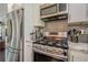 Modern kitchen features stainless steel appliances, gray backsplash, and stone countertops at 205 Plantation Sw Rd, Smyrna, GA 30082