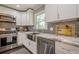 Bright kitchen features stainless steel appliances, gray backsplash, and white cabinets at 205 Plantation Sw Rd, Smyrna, GA 30082