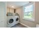 Bright laundry room featuring a modern washer and dryer, and a window overlooking the yard at 205 Plantation Sw Rd, Smyrna, GA 30082