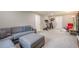 Spacious living room with plush gray sofa, a large ottoman, and exercise equipment in the background at 205 Plantation Sw Rd, Smyrna, GA 30082