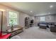 Bright living room featuring a comfortable gray sofa, entertainment center, and large windows at 205 Plantation Sw Rd, Smyrna, GA 30082