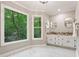 Well-lit bathroom with and vanities, marble floors, granite countertop and treed view at 1183 Woods Ne Cir, Atlanta, GA 30324