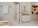 Well-lit bathroom with marble floors, granite countertop, octagon mirror and white cabinets at 1183 Woods Ne Cir, Atlanta, GA 30324