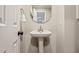 Charming half bathroom features a pedestal sink, decorative mirror, and modern fixtures at 1183 Woods Ne Cir, Atlanta, GA 30324