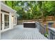 Backyard deck features a relaxing hot tub, perfect for outdoor entertaining, with trees and a privacy fence at 1183 Woods Ne Cir, Atlanta, GA 30324