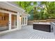 Backyard deck features a relaxing hot tub and french doors to the home, perfect for outdoor entertaining at 1183 Woods Ne Cir, Atlanta, GA 30324