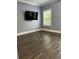 Light filled bedroom featuring dark LVP flooring, grey walls, and a large window at 1462 Knights Trl, Stone Mountain, GA 30083