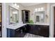 Bathroom features a dual sink vanity, dark cabinets, granite countertops, and large mirrors at 3909 Obryant Se Cir, Smyrna, GA 30082