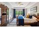 Charming bedroom with decorative wardrobe, tray ceiling and large windows with blue curtains at 3909 Obryant Se Cir, Smyrna, GA 30082