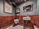 Unique basement bathroom with wood paneled walls, rustic-framed mirrors, and a compact sink and toilet at 646 Darlington Ne Cir, Atlanta, GA 30305